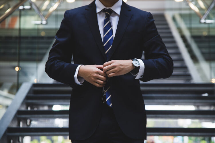 man wearing a business suit stepping down a set of stairs