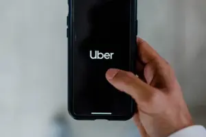 man holding a phone, using the Uber app. man holding a phone, using the Uber app.
