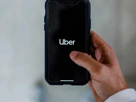 man holding a phone, using the Uber app.